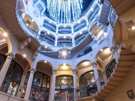 Rotunda at the Mission inn, bright blue-and-white lights sparkle above ornate balconies and arches.